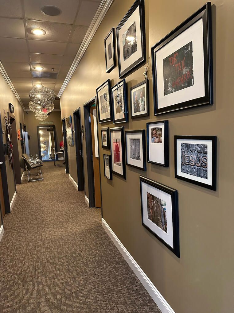 The gallery hall: framed photographs along a warm hallway